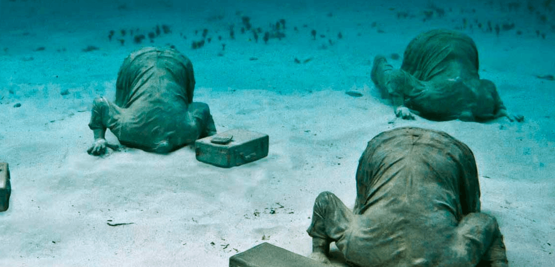 banquiers sculpture tete enfoncée dans le sable musée sous-marin de Cancun