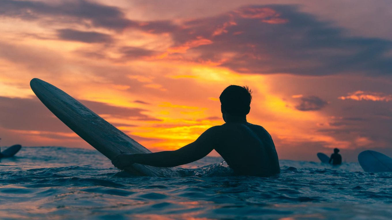 dramatic surfing scene at sunset